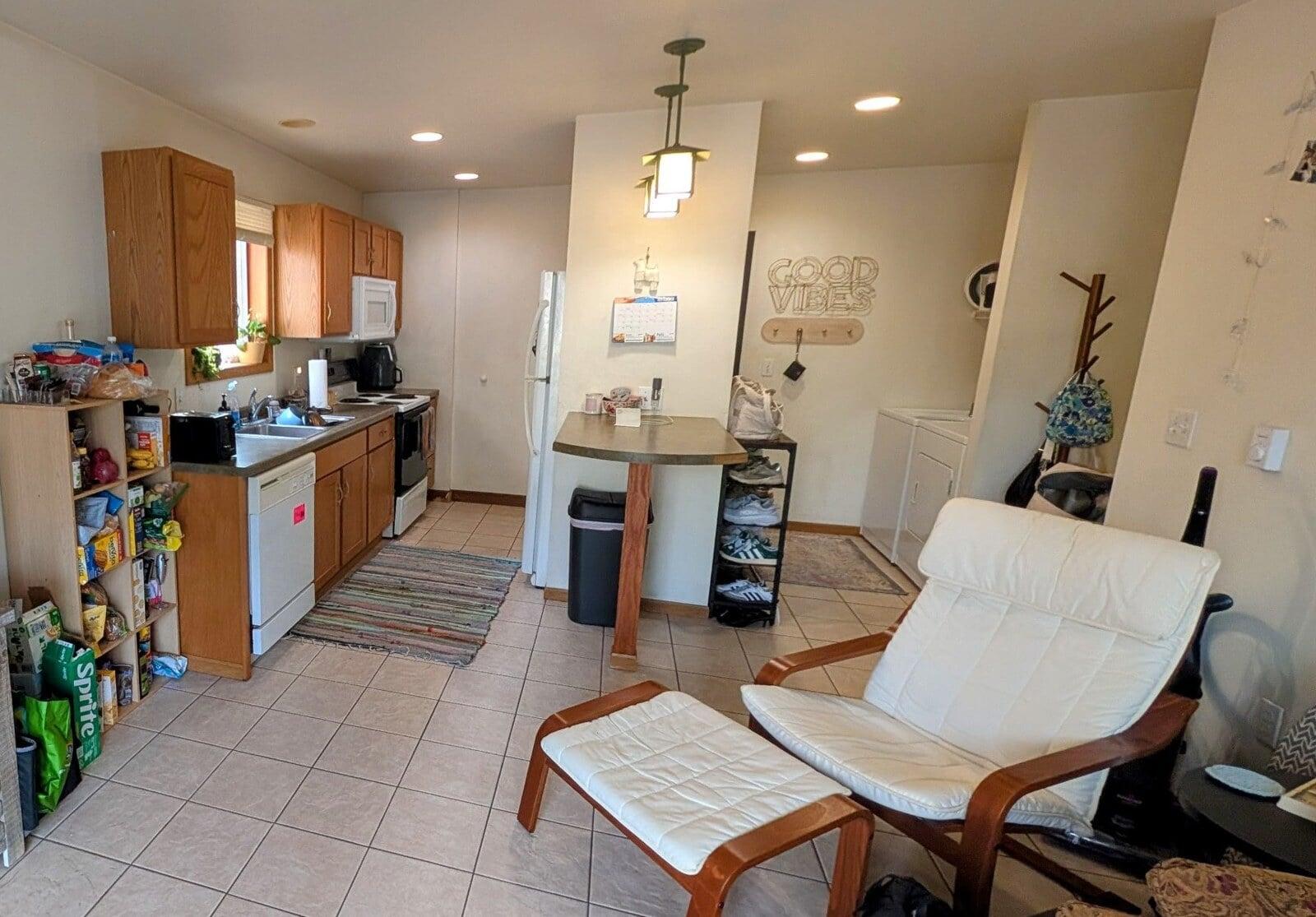 Open kitchen and living room with in-unit washer and dryer in an off-campus apartment in La Crosse, WI